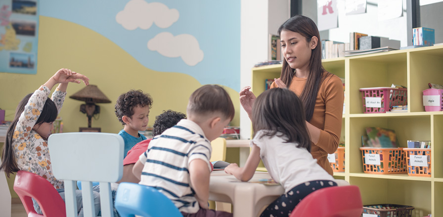 Educator leading a small-group activity with children in the White Rock classroom.